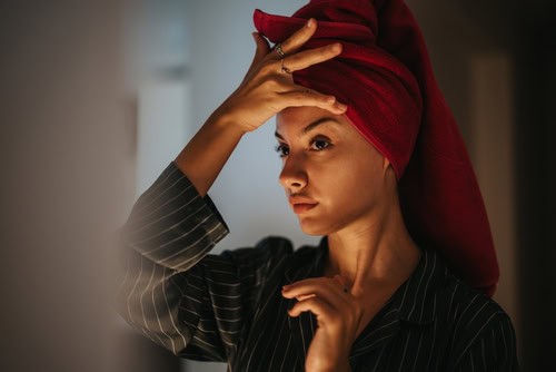 Woman checking her skin after cleansing as part of her evening skincare routine